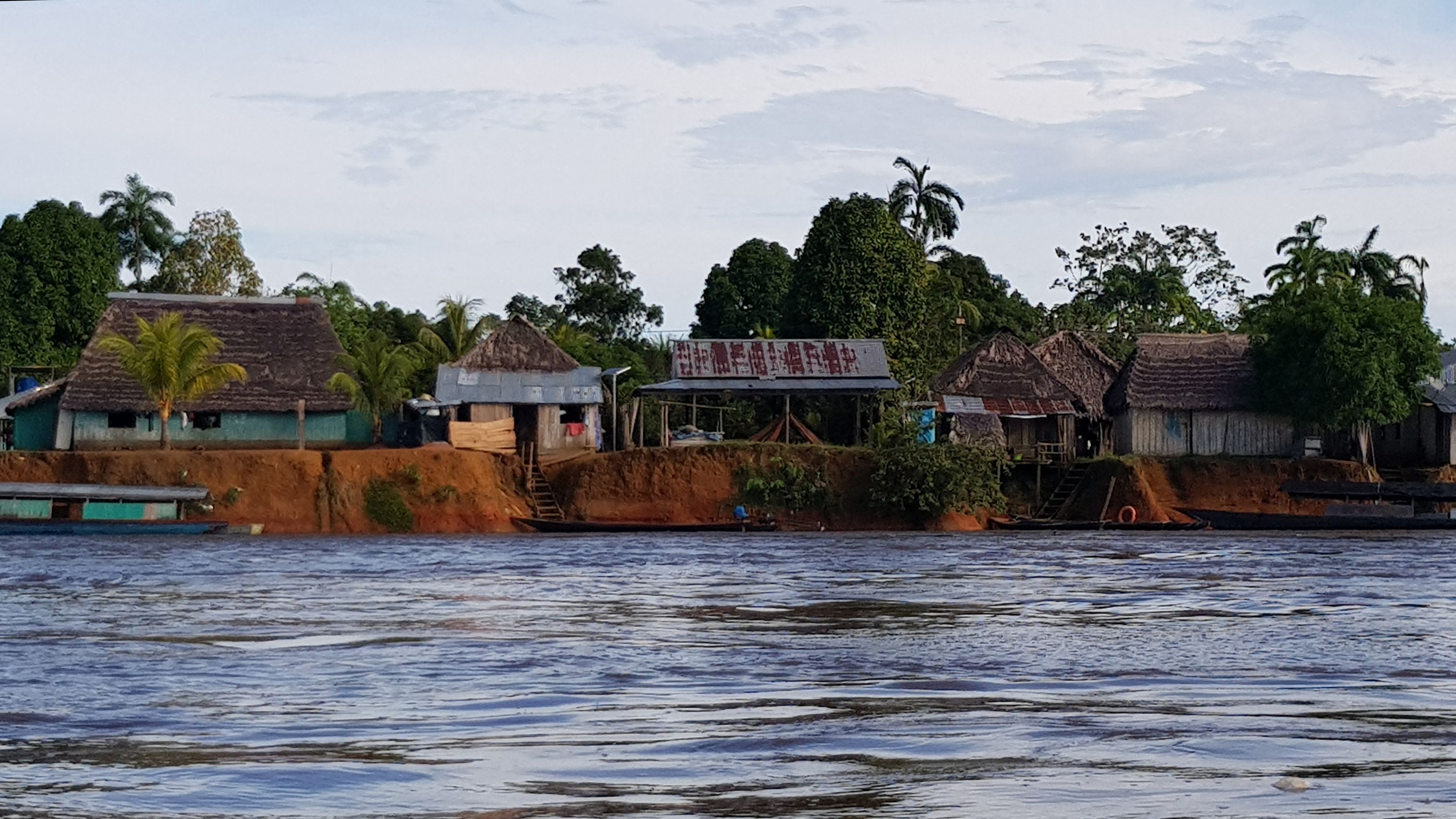 a landscape of various house structures alond the riverbanks of the Pastaza River.